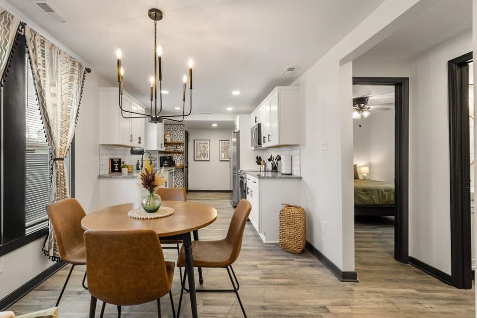 Sun‑filled dining area with a modern chandelier and seating for four—perfect for slow mornings or cozy dinners in. Located centrally between living area and kitchen to keep the good times rolling!