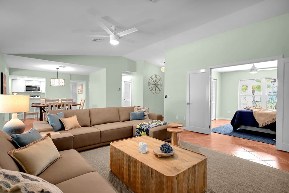 Open living room. complete with a 65" smart TV ready to stream whatever services you use! Leather couch and love seat, open and airy.
