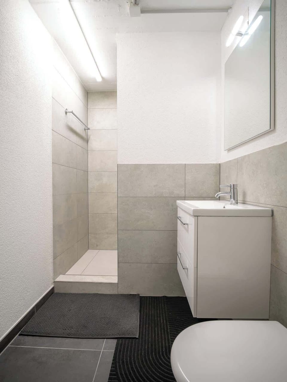 Shared bathroom with sink, toilet, and clean design