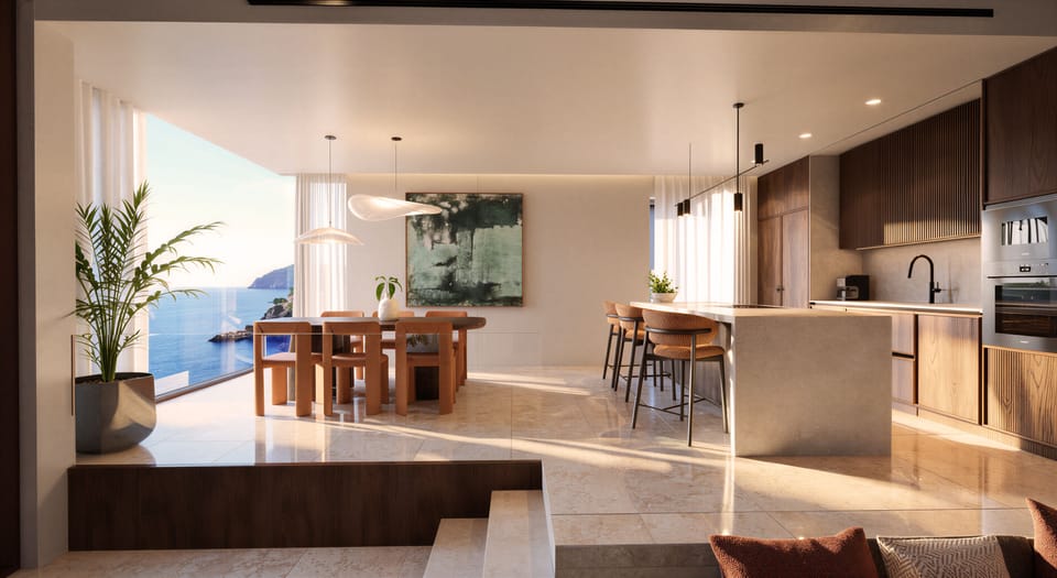 An elegant indoor kitchen and open-plan dining area capture sweeping sea views, 