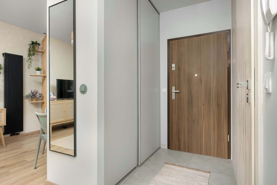An entryway area with a wardrobe and a mirror, offering storage for coats and shoes. The design is minimalistic and well-organized, making it convenient for everyday use.