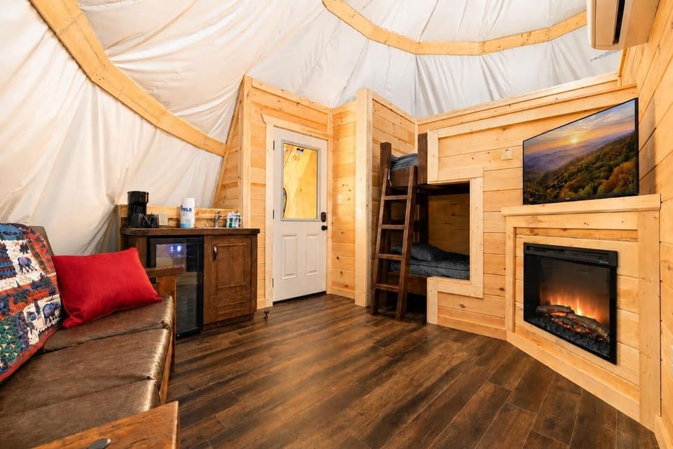 Cozy rustic living space blending cabin feel, glamping style, and family-friendly bunk beds in smoky mountain resort stay.