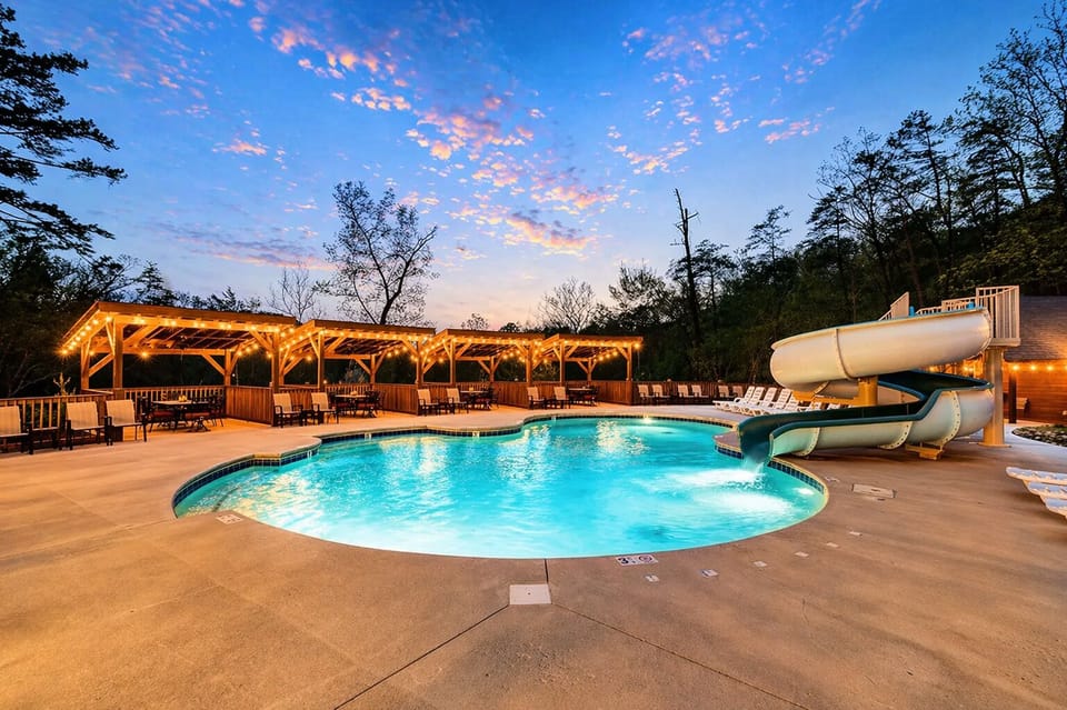 Outdoor resort pool  with water slide and scenic Smoky Mountain backdrop.
