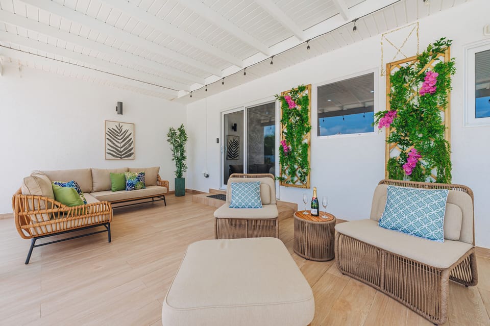 Covered lounge area with comfortable seating and greenery accents