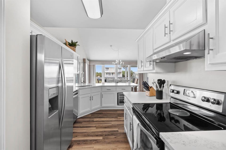Your fully equipped kitchen features modern stainless steel appliances and gleaming white cabinetry, perfect for creating memorable meals during your stay.