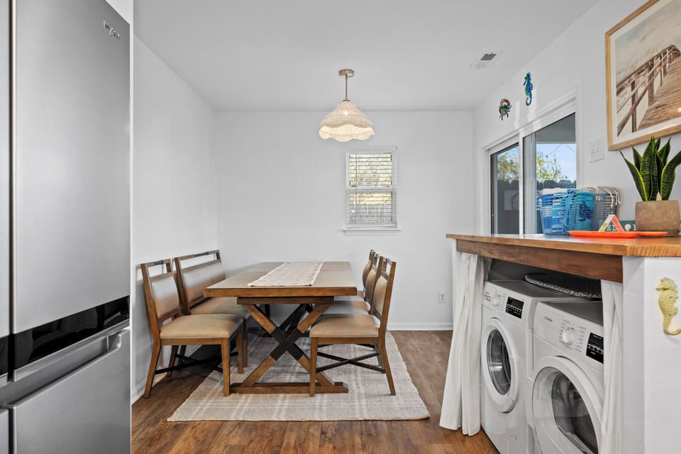 Gather around this elegant dining table for memorable meals, with convenient laundry access tucked stylishly nearby for your comfort.