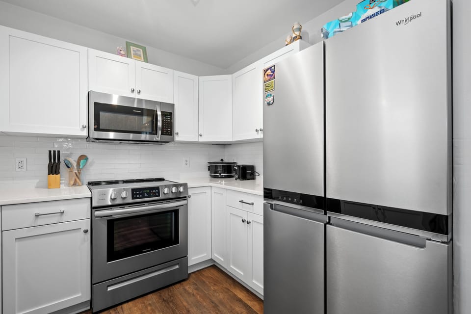 Cook your favorite meals in this fully equipped kitchen with modern stainless steel appliances and plenty of storage space.