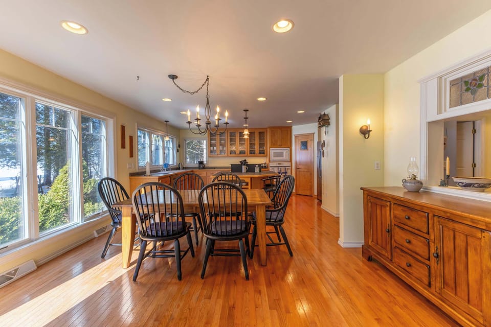 Gather around this warm dining space with beautiful lake views streaming through oversized windows, creating the perfect backdrop for your morning coffee.
