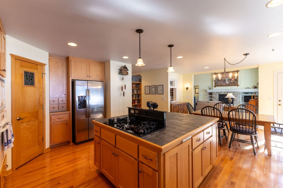 Spacious kitchen features warm wood cabinetry, large countertop space, and a central island perfect for cooking and casual meals.