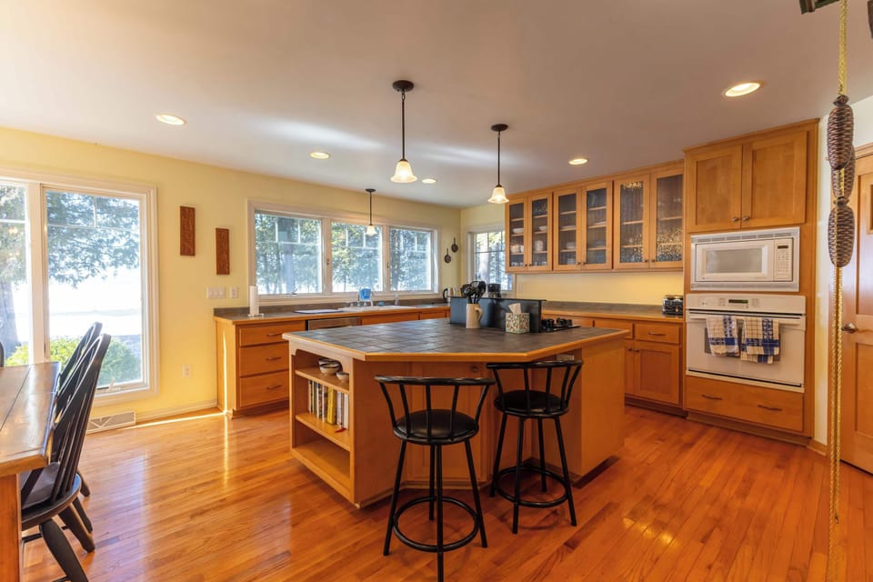 Spacious kitchen features warm wood cabinetry, large countertop space, and a central island perfect for cooking and casual meals.