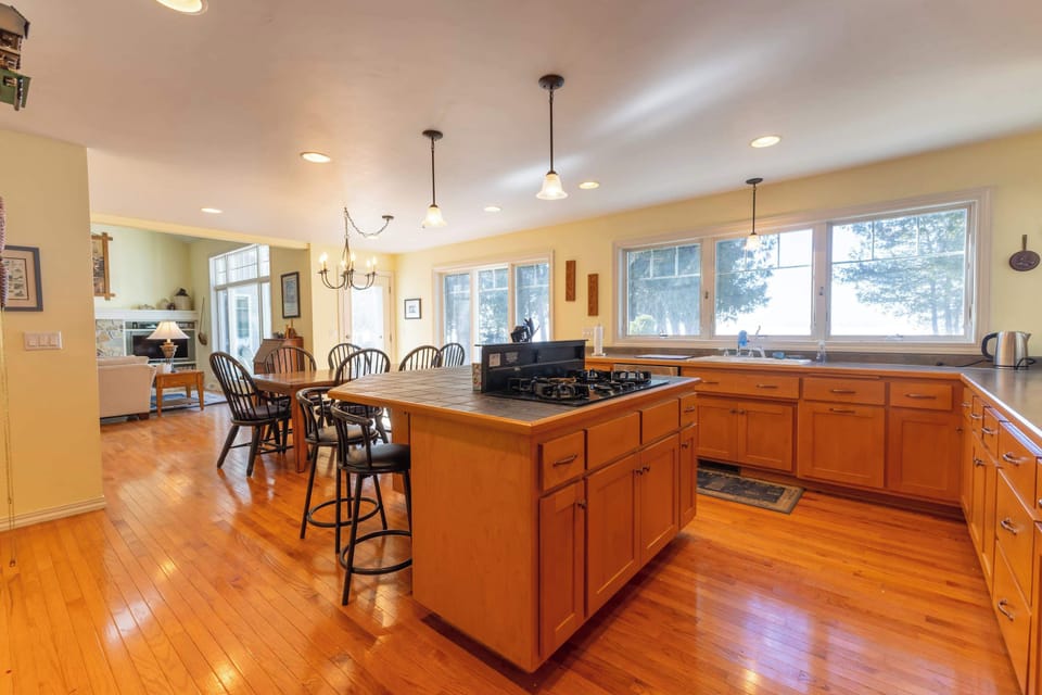 Spacious kitchen features warm wood cabinetry, large countertop space, and a central island perfect for cooking and casual meals.