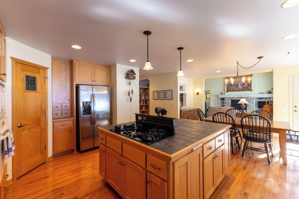 Spacious kitchen features warm wood cabinetry, large countertop space, and a central island perfect for cooking and casual meals.