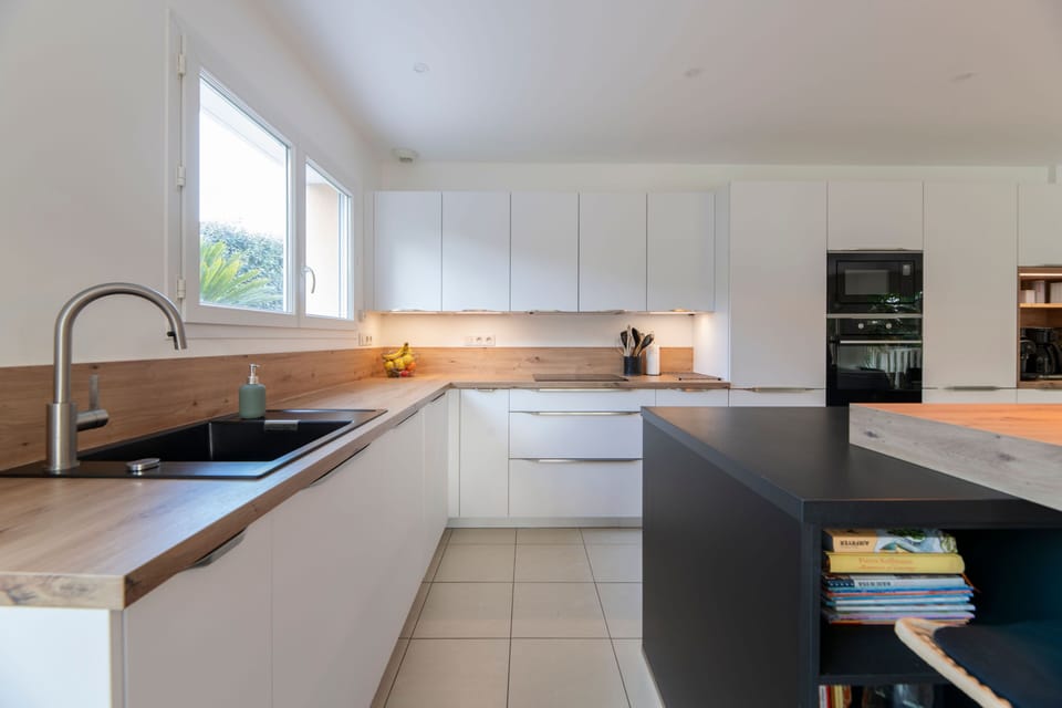 Cook up a storm in the modern kitchen, featuring sleek cabinetry and a seamless flow of light.