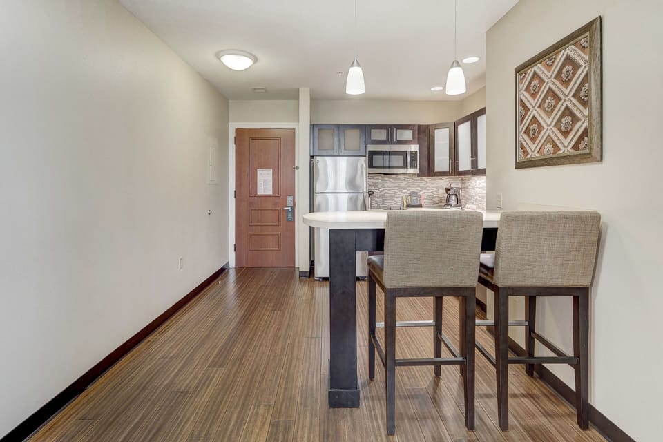 Modern kitchen with stainless steel appliances and stylish bar seating.