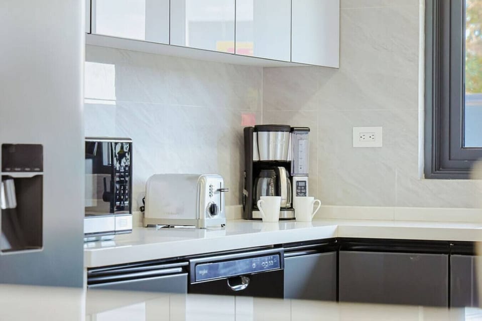 Bright and spacious modern kitchen with sleek cabinetry, high-end appliances, and a stylish breakfast bar with seating—perfect for cooking, dining, and gathering.