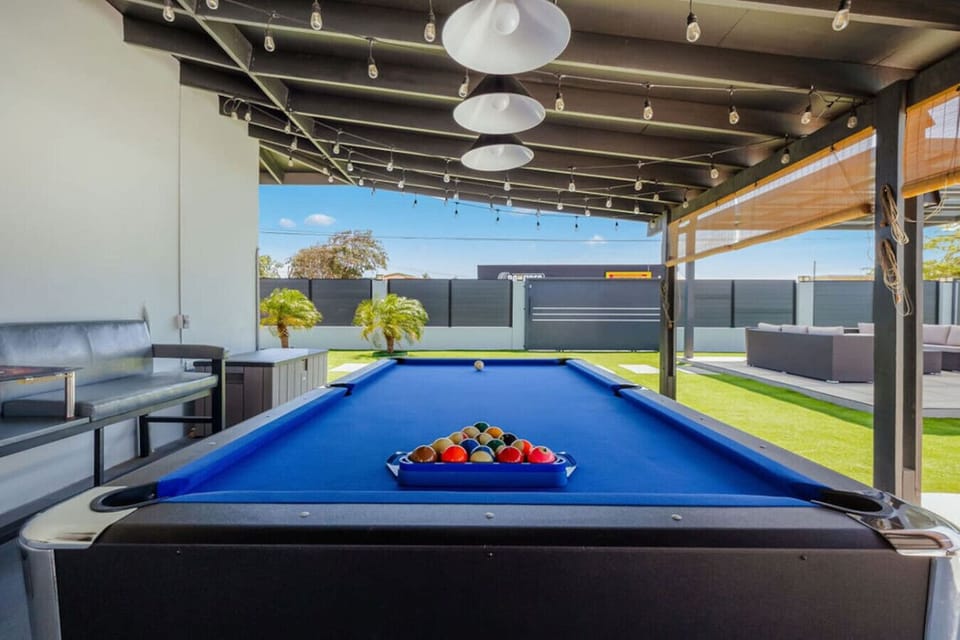 Fun-filled covered patio featuring a pool table, cozy seating, and ambient string lights—perfect for game nights and relaxed hangouts.