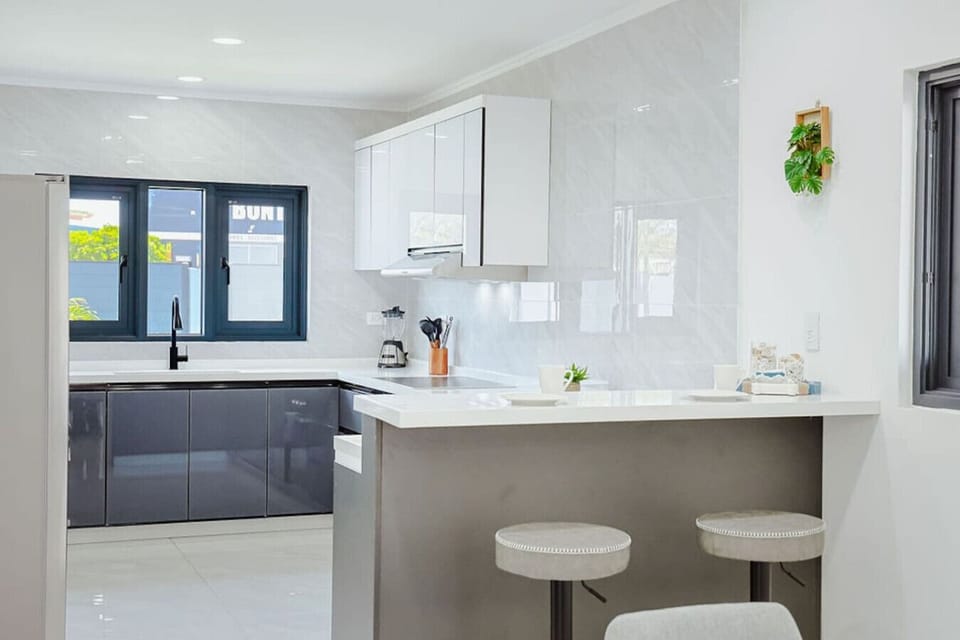Bright and spacious modern kitchen with sleek cabinetry, high-end appliances, and a stylish breakfast bar with seating—perfect for cooking, dining, and gathering.