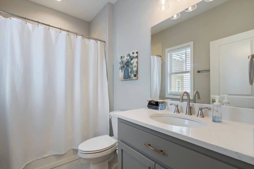 Clean full bathroom w/ sink, mirror & shower-tub combo for everyday ease