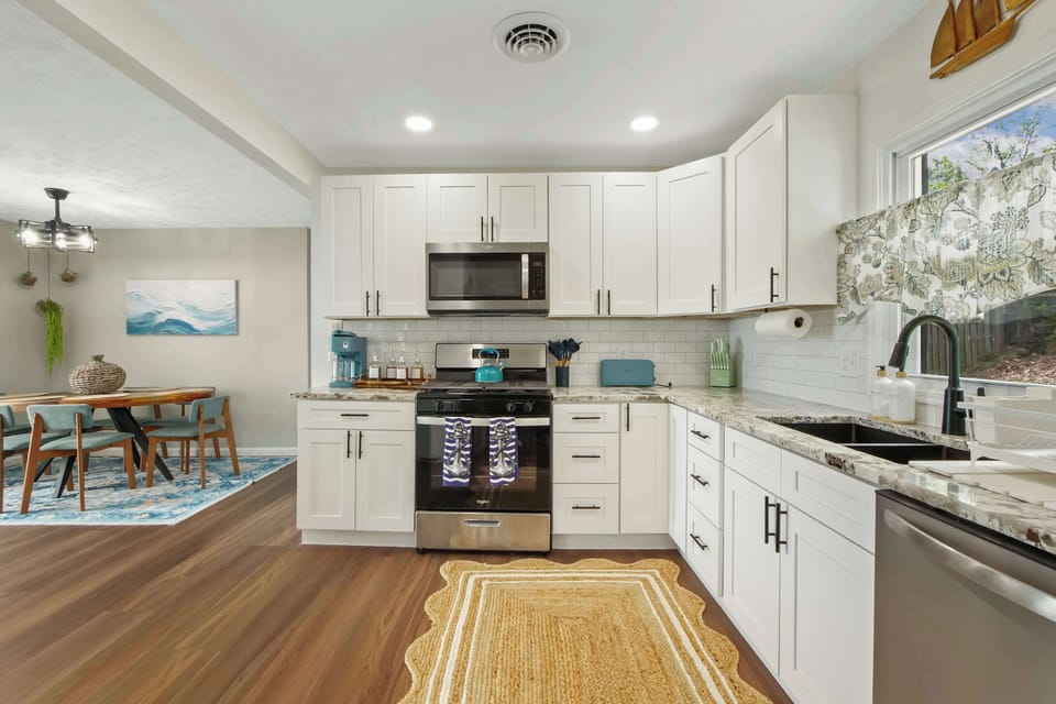 Spacious kitchen w/ stainless appliances, ample counters & warm wood floors