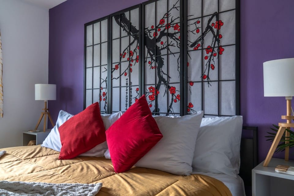 Primary Bedroom Suite: Sink into a restful night`s sleep in this peaceful master bedroom featuring a plush king mattress outfitted with premium linens, vibrant accent pillows, bedside table lamps, and a Japanese-inspired Shoji screen headboard accent agai