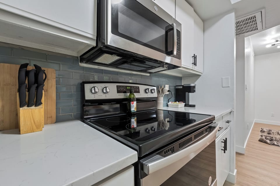 Modern Kitchen with stove, microwave, coffee maker, and essential cookware.