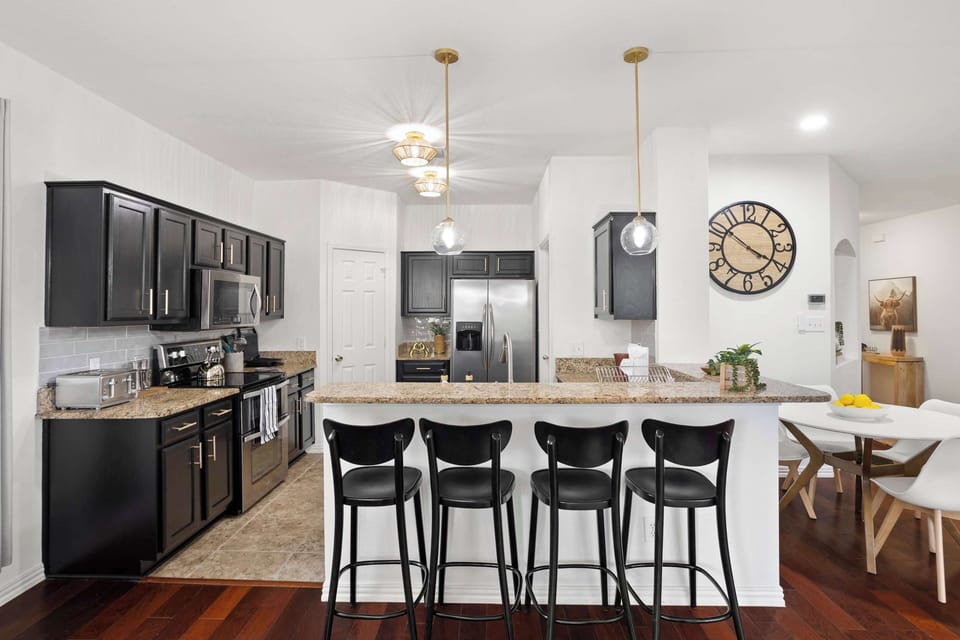 Sleek, fully equipped kitchen with granite counters and bar seating—perfect for cooking, chatting, and gathering.