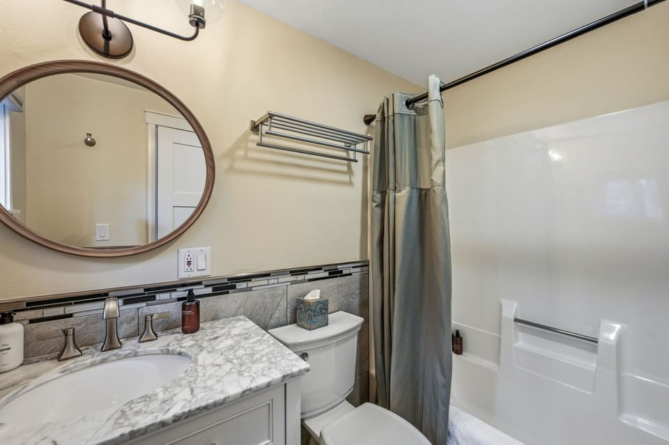Fresh and inviting bathroom with marble vanity, modern finishes, and a spacious tub and shower.