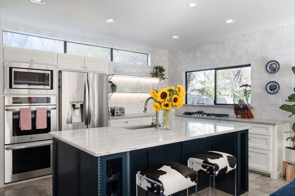 Stunning white marble kitchen with modern appliances and ample counter space.