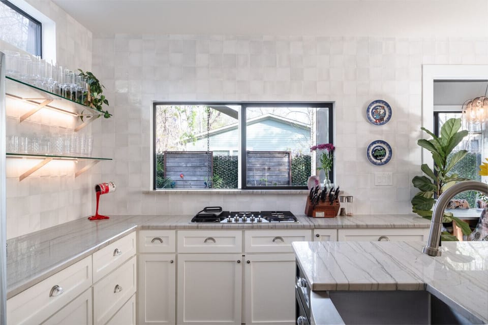 Stunning white marble kitchen with ample storage, modern appliances and fully stocked with essentials.
