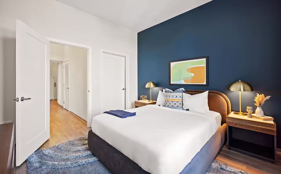 Settle in comfortably with warm lighting and thoughtful bedside details.