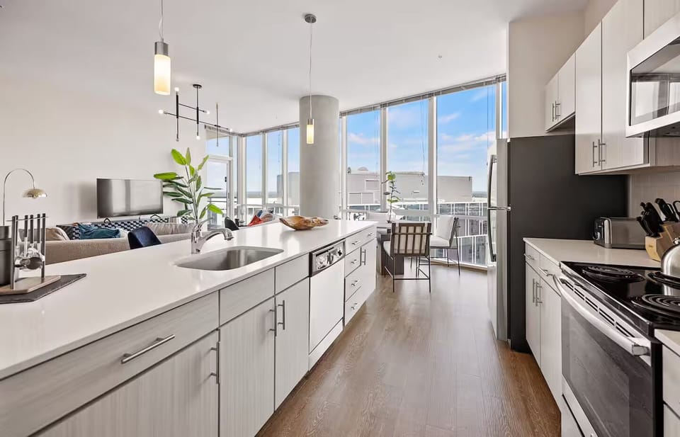 Cook together in a sunlit kitchen opening to skyline views.