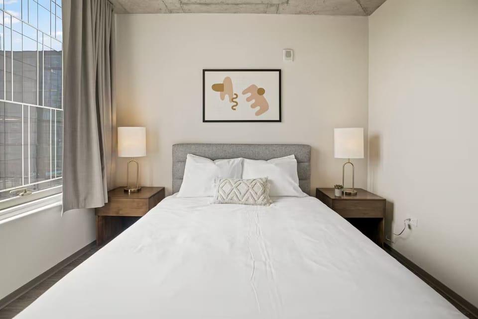 Drift off in crisp linens beside bright city-facing windows.