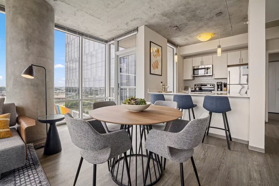 Dine together in an open layout framed by skyline light.