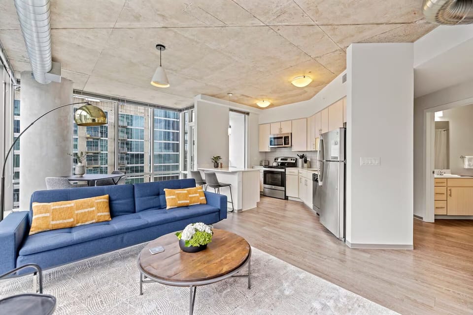 Lounge in sunlit comfort with open-concept space and skyline backdrop.