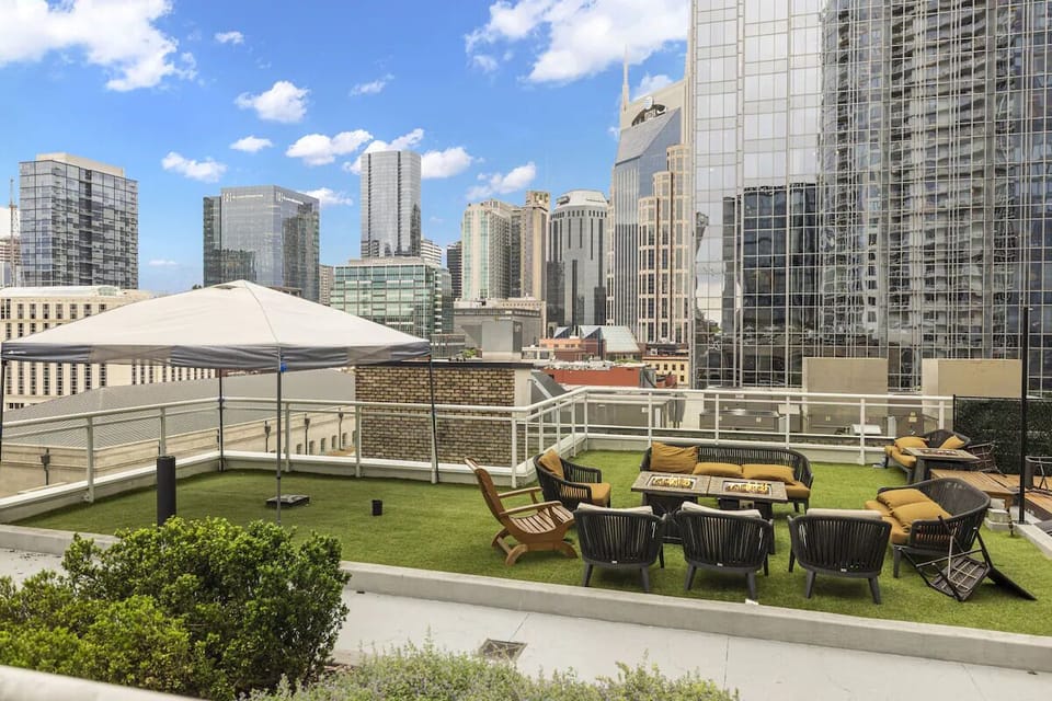 Unwind on the rooftop lawn with panoramic city skyline views.