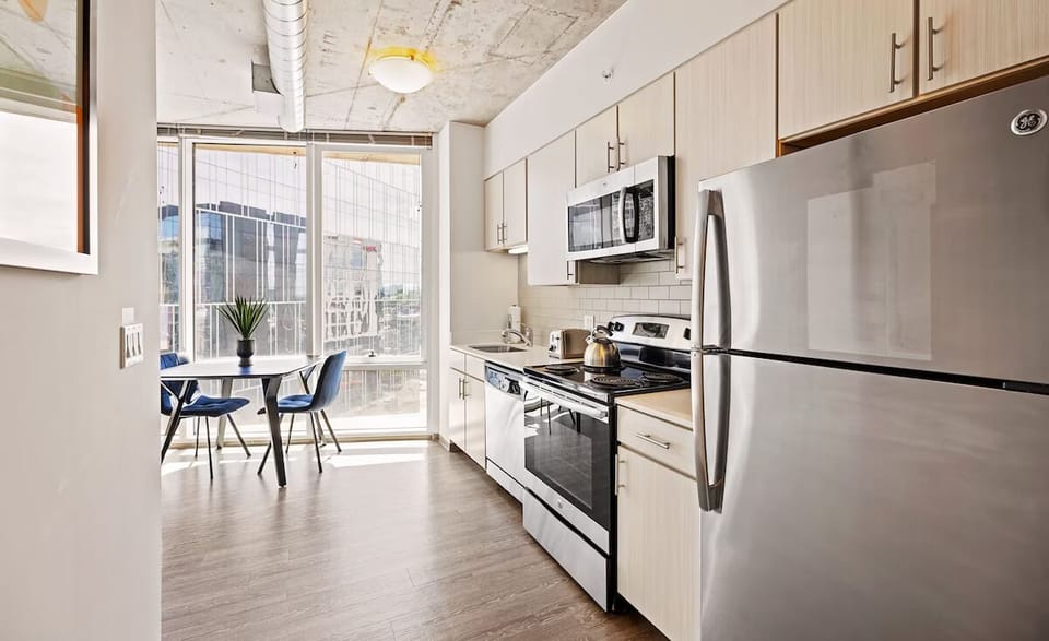 Prepare meals in a sleek kitchen with sunlit dining nook.