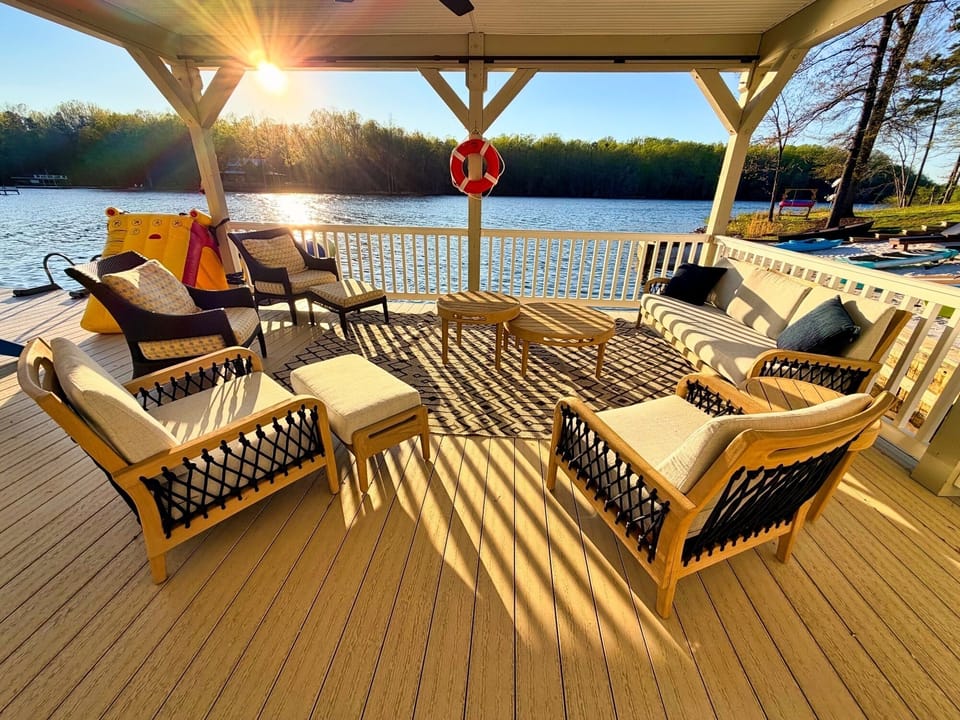 Covered lakefront lounge with plush seating and sunset-ready views