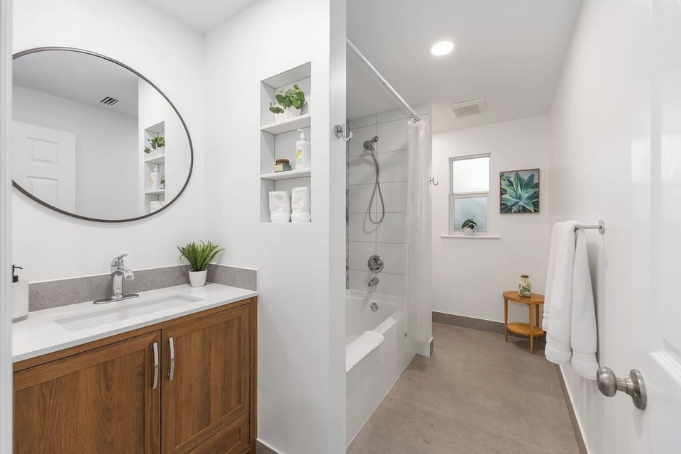 Newly renovated bathroom has extra towels below sink and the shower is stocked with shampoo, body wash and conditioner for guest use.