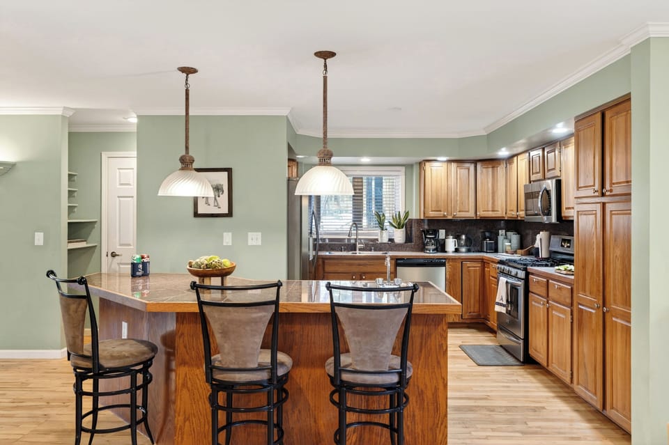 Spacious kitchen with barstool seating and modern appliances.