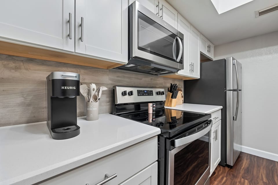 coffee Maker, stove, countertops, utensils, cabinets, refrigerator and oven
