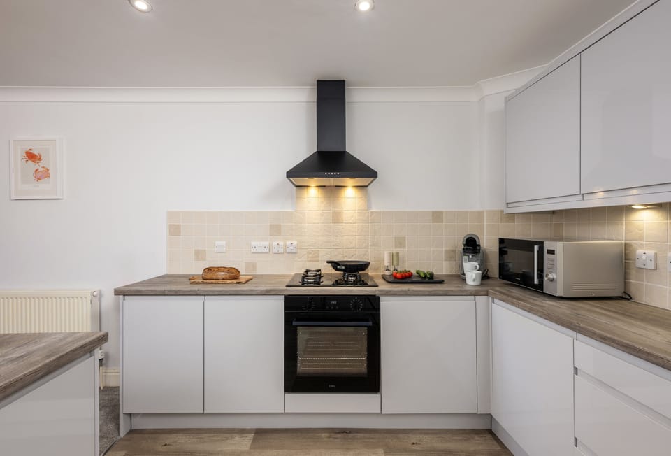 1 Golden Bay, Newquay: Fully equipped kitchen with a central island offering additional storage