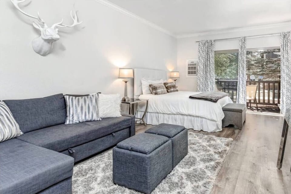 Relax in your stylish studio with plush seating, crisp linens, and peaceful balcony views—the perfect mountain retreat.