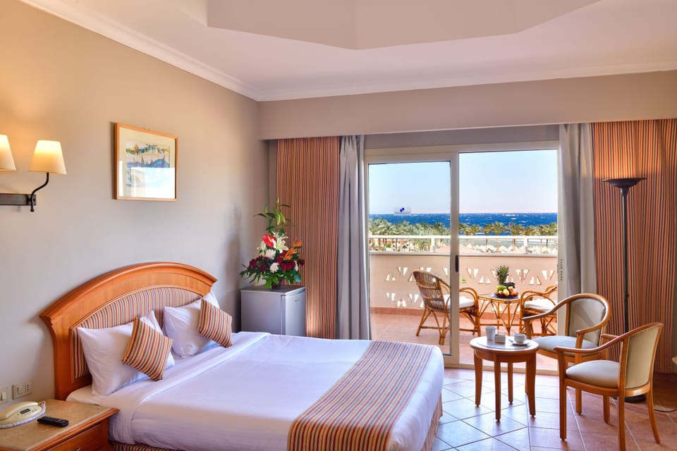 Deluxe Room, Sea View | Minibar, in-room safe, laptop workspace, blackout drapes