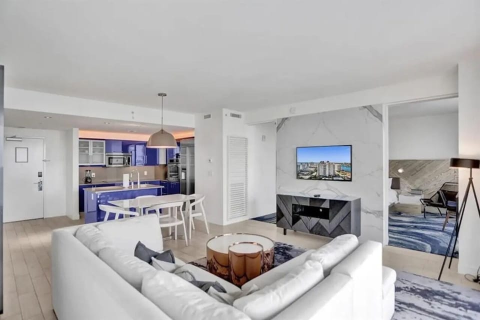 Spacious living room with dedicated workspace, natural light, and modern design in this Fort Lauderdale beachfront condo.