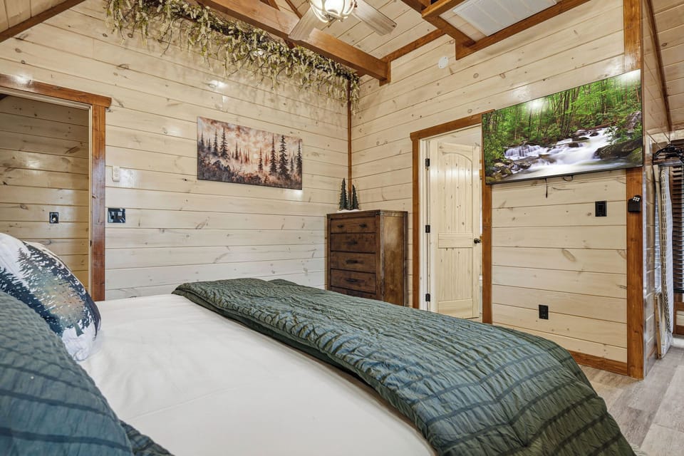Drift off to sleep in your cozy cabin bedroom with rustic wood walls, nature-inspired art, and peaceful forest vibes throughout.