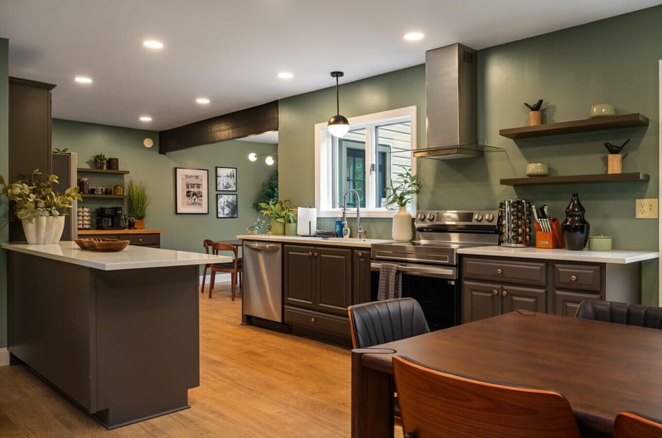 Imagine cooking here while the group gathers just beyond the peninsula—dining table in view, a full kitchen with everything you need, and a breakfast nook tucked in back for quiet mornings.