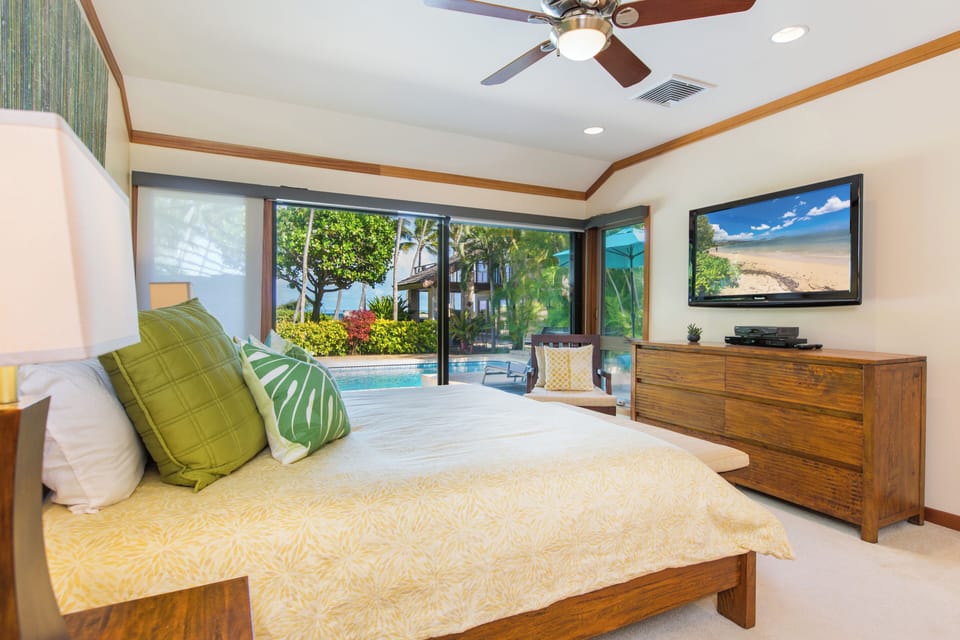 Wake up to garden views from this peaceful guest house bedroom with lanai access.