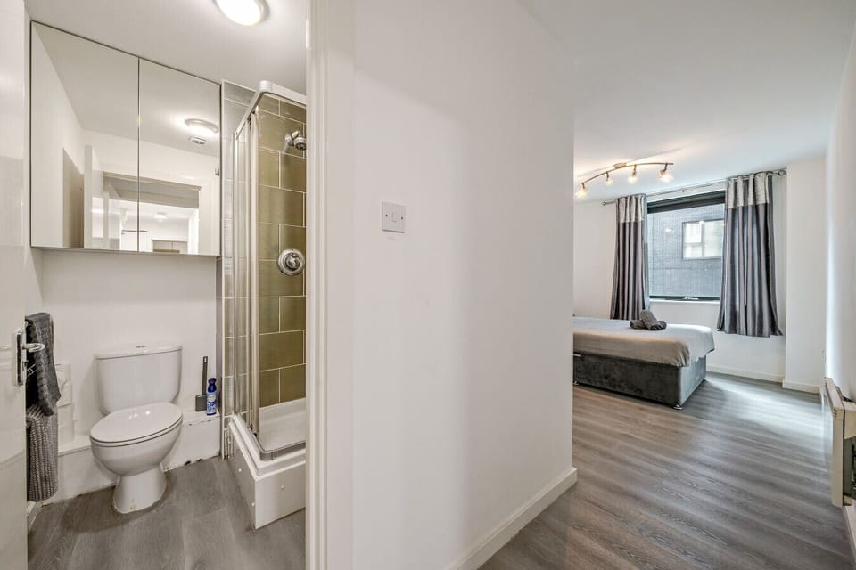 A convenient layout with the bathroom off the hallway and the bedroom visible ahead.