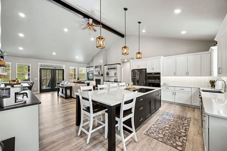 Adjacent to the dining space is the spacious kitchen, complete with seating at the island for casual meals or conversation. It’s a perfect blend of style and functionality, ideal for cooking and socializing.