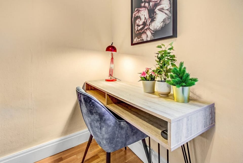 A quiet work-from-home corner with a stylish desk and warm lamp for long stays.